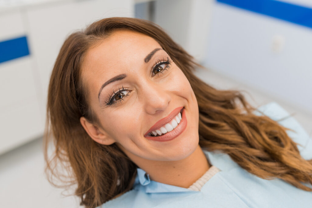 A female sitting in the dental chair with straight white teeth