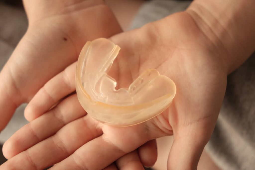 Patient holding a night guard for bruxism