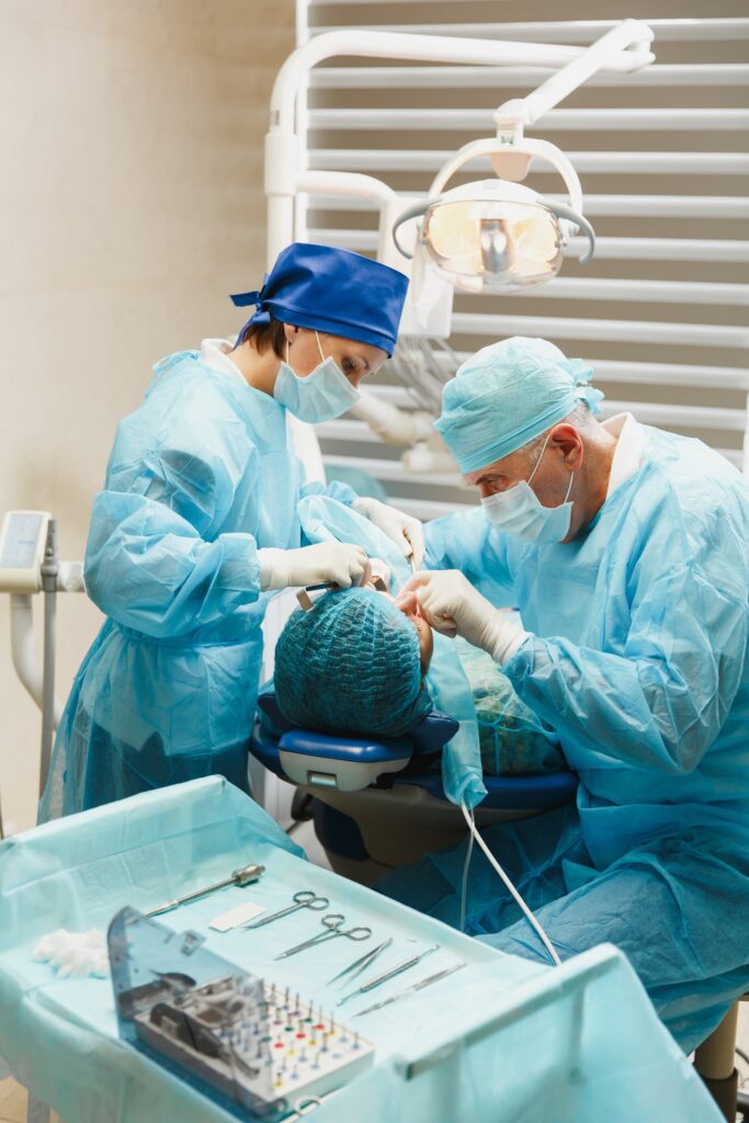Dentist performing oral surgery on a patient